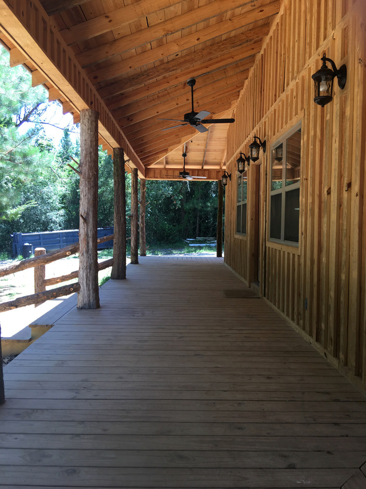 Large mountain style front porch idea with decking and a roof extension