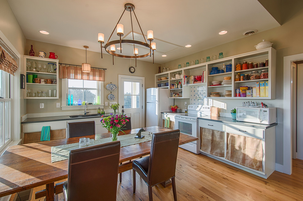 This is an example of a country l-shaped eat-in kitchen in Other with an undermount sink, open cabinets, white cabinets, white appliances, medium hardwood floors, no island and brown floor.