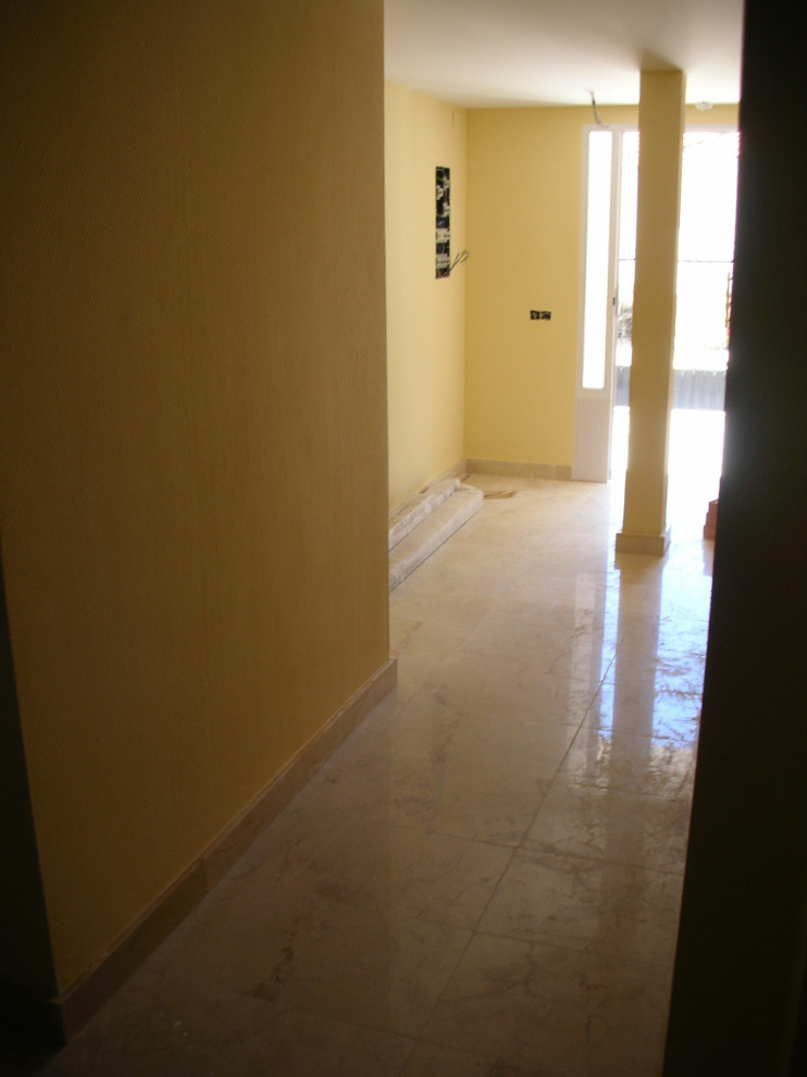 This is an example of an expansive modern foyer in Other with yellow walls, marble floors, a double front door, a white front door, beige floor and wallpaper.