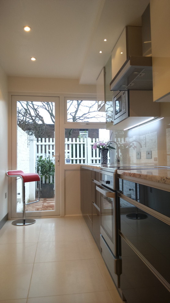 Small modern single-wall separate kitchen in London with glass-front cabinets, no island, a drop-in sink, granite benchtops, white splashback, glass sheet splashback, panelled appliances, porcelain floors and white floor.
