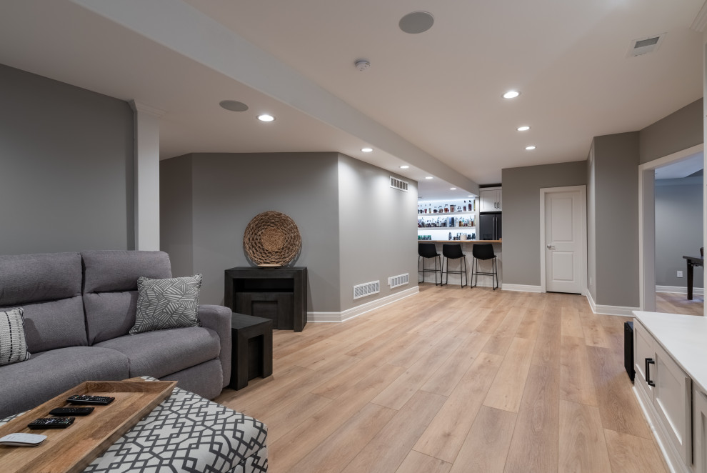 Inspiration for a mid-sized modern underground vinyl floor and beige floor basement remodel in San Diego with a bar and gray walls