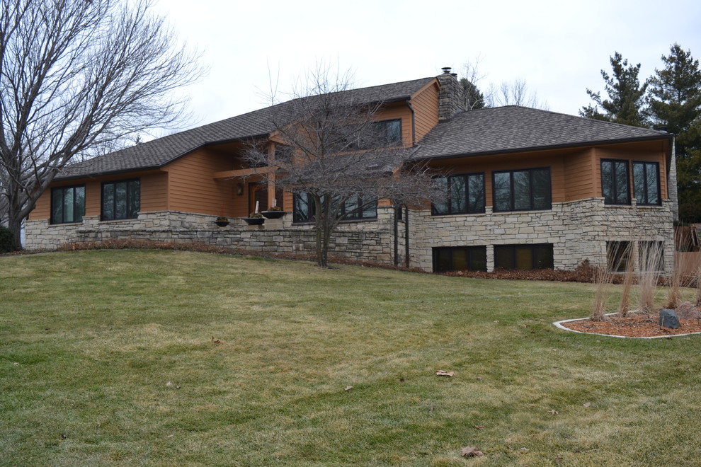 Inspiration for a large transitional brown three-story concrete fiberboard house exterior remodel with a hip roof and a shingle roof