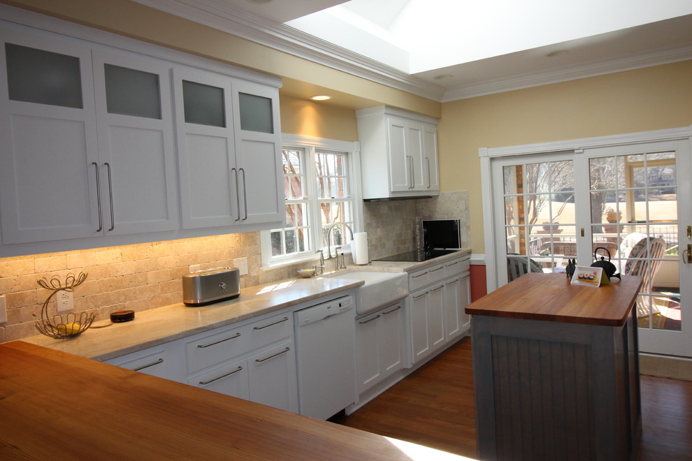 Eat-in kitchen - mid-sized transitional u-shaped medium tone wood floor eat-in kitchen idea with a farmhouse sink, shaker cabinets, yellow cabinets, marble countertops, beige backsplash, stone tile backsplash, stainless steel appliances and an island