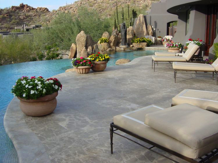 Large backyard patio in Phoenix with a water feature, natural stone pavers and a roof extension.