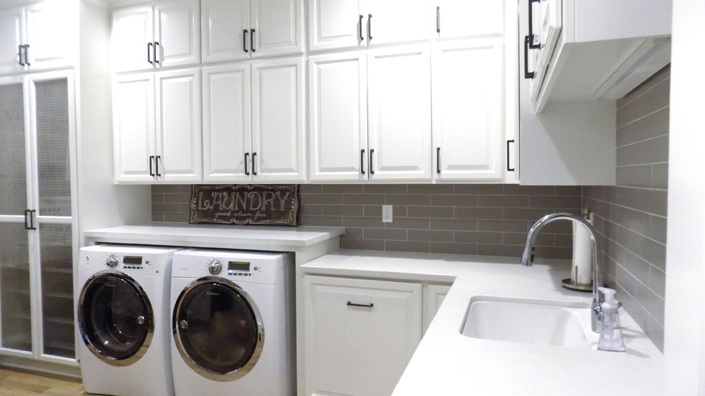 Inspiration for a large country u-shaped utility room in San Luis Obispo with a single-bowl sink, raised-panel cabinets, white cabinets, quartz benchtops, grey walls, light hardwood floors and a side-by-side washer and dryer.