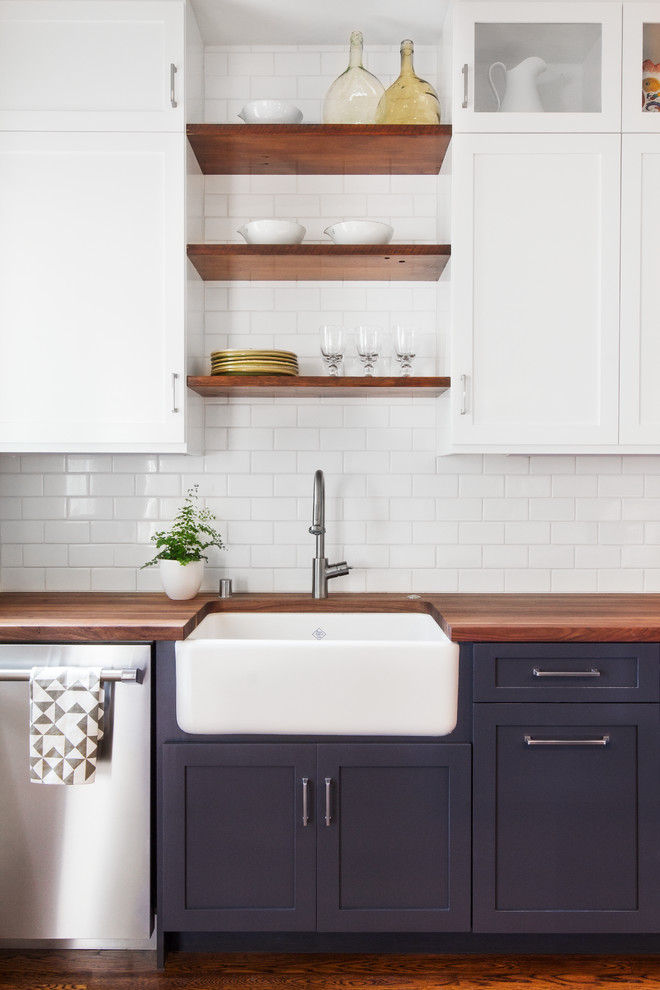 Design ideas for a mid-sized contemporary l-shaped eat-in kitchen in San Francisco with a farmhouse sink, recessed-panel cabinets, white cabinets, wood benchtops, white splashback, stainless steel appliances, medium hardwood floors, with island and subway tile splashback.