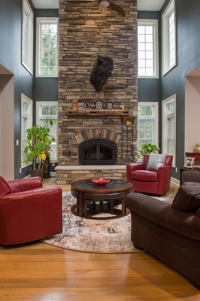 Inspiration for a mid-sized country formal living room in Boston with grey walls, light hardwood floors, a standard fireplace, a stone fireplace surround, no tv and beige floor.