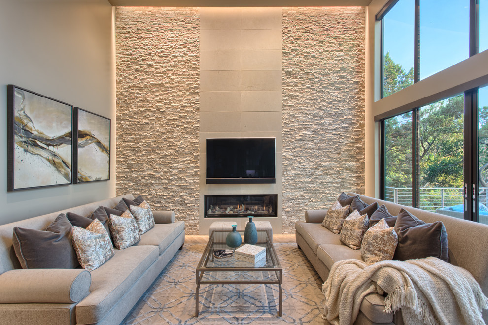 This is an example of a contemporary family room in Austin with a ribbon fireplace, a wall-mounted tv and beige walls.