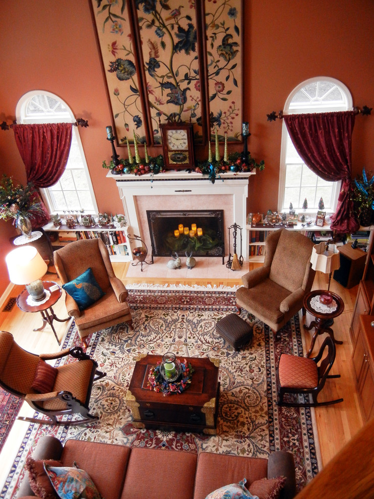 This is an example of a large traditional open concept living room in New York with orange walls, medium hardwood floors, a standard fireplace, a stone fireplace surround and no tv.