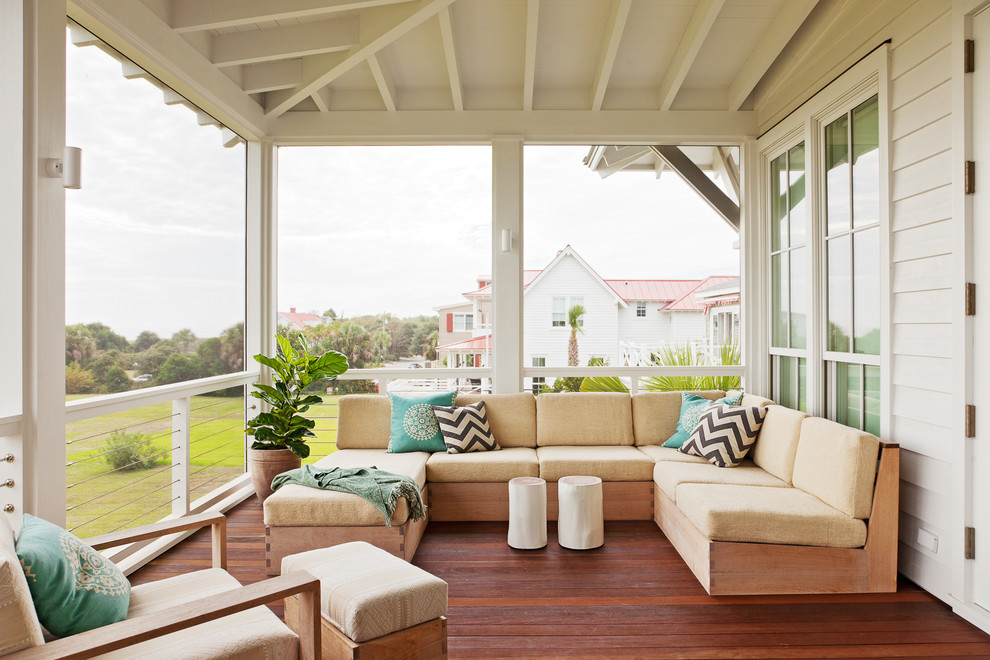 This is an example of a beach style backyard screened-in verandah in Charleston with a roof extension.