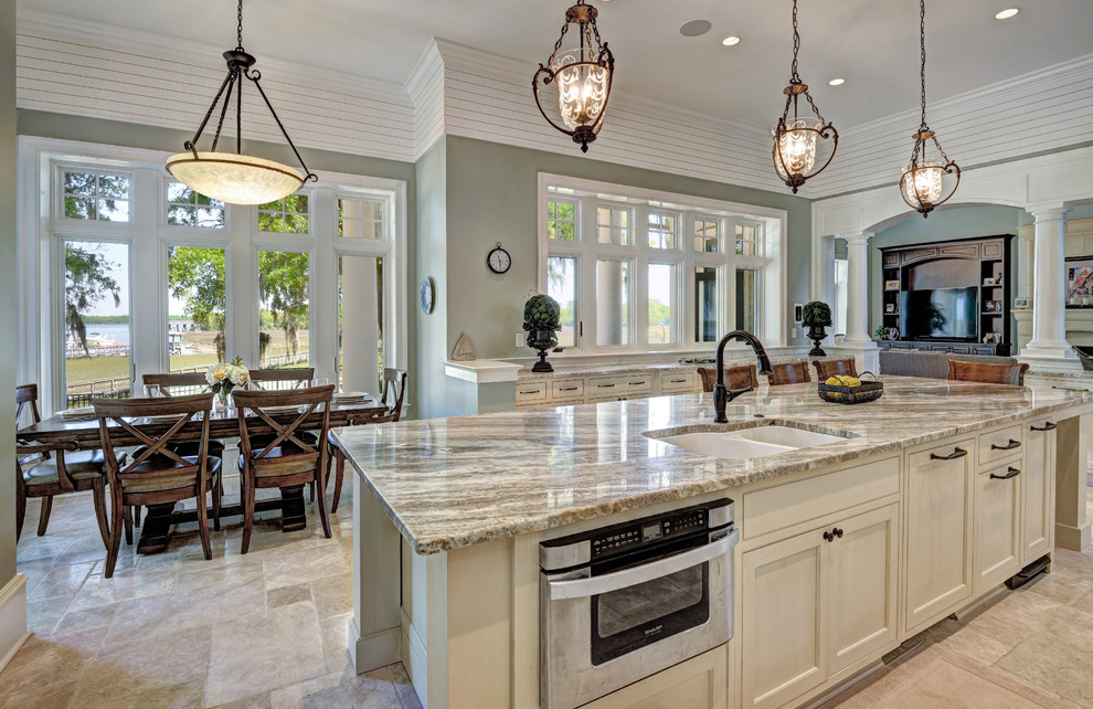 Inspiration for a large transitional u-shaped enclosed kitchen remodel in Charleston with an undermount sink, beaded inset cabinets, beige cabinets, white backsplash, stone tile backsplash, paneled appliances and an island