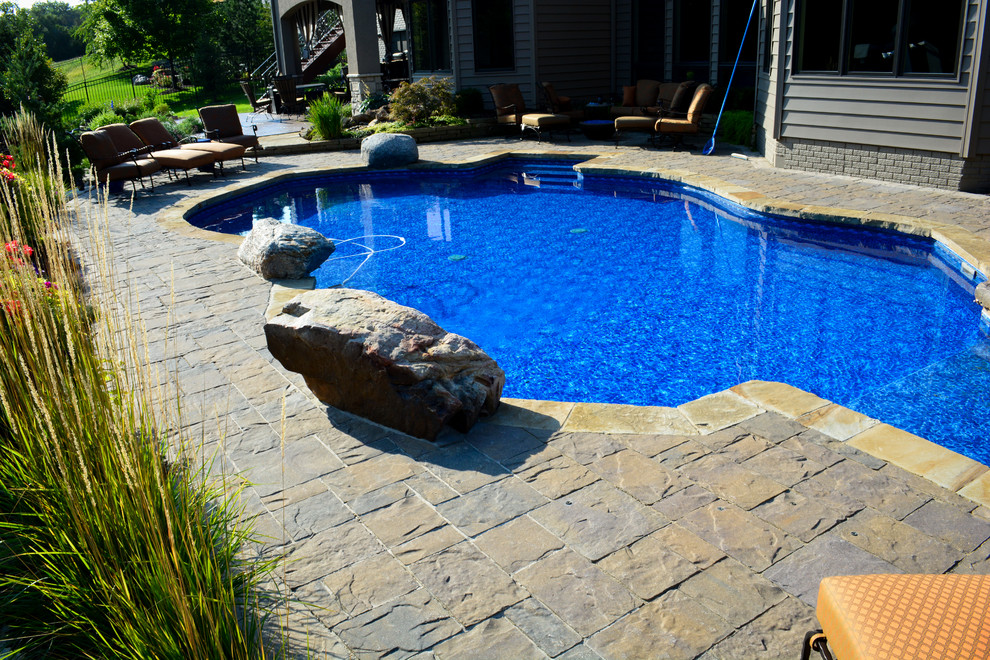 Example of a mid-sized mountain style backyard gravel and custom-shaped pool fountain design in Omaha