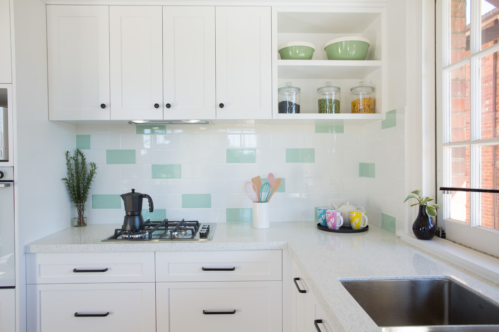 Design ideas for a mid-sized traditional u-shaped separate kitchen in Brisbane with a double-bowl sink, shaker cabinets, white cabinets, quartz benchtops, green splashback, subway tile splashback, white appliances, dark hardwood floors, no island, red floor and white benchtop.