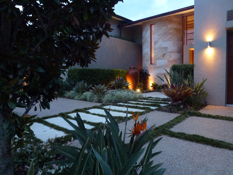 This is an example of a mid-sized contemporary front yard partial sun driveway in Gold Coast - Tweed with a garden path and concrete pavers.
