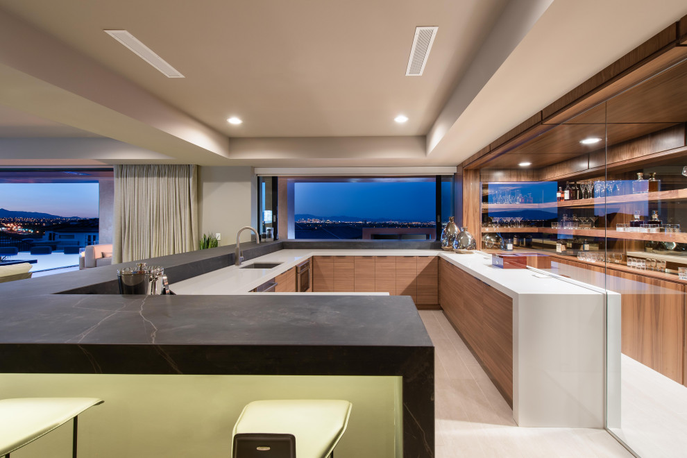 Design ideas for a mid-sized contemporary u-shaped seated home bar in Las Vegas with a drop-in sink, flat-panel cabinets, brown cabinets, granite benchtops, glass sheet splashback, porcelain floors, white floor and black benchtop.