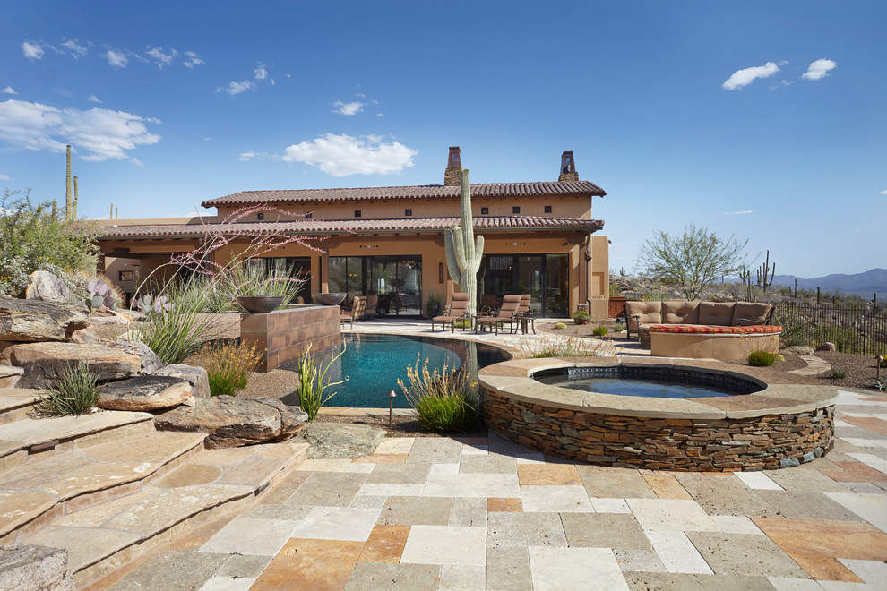Design ideas for an expansive backyard patio in Phoenix with a water feature, natural stone pavers and a roof extension.