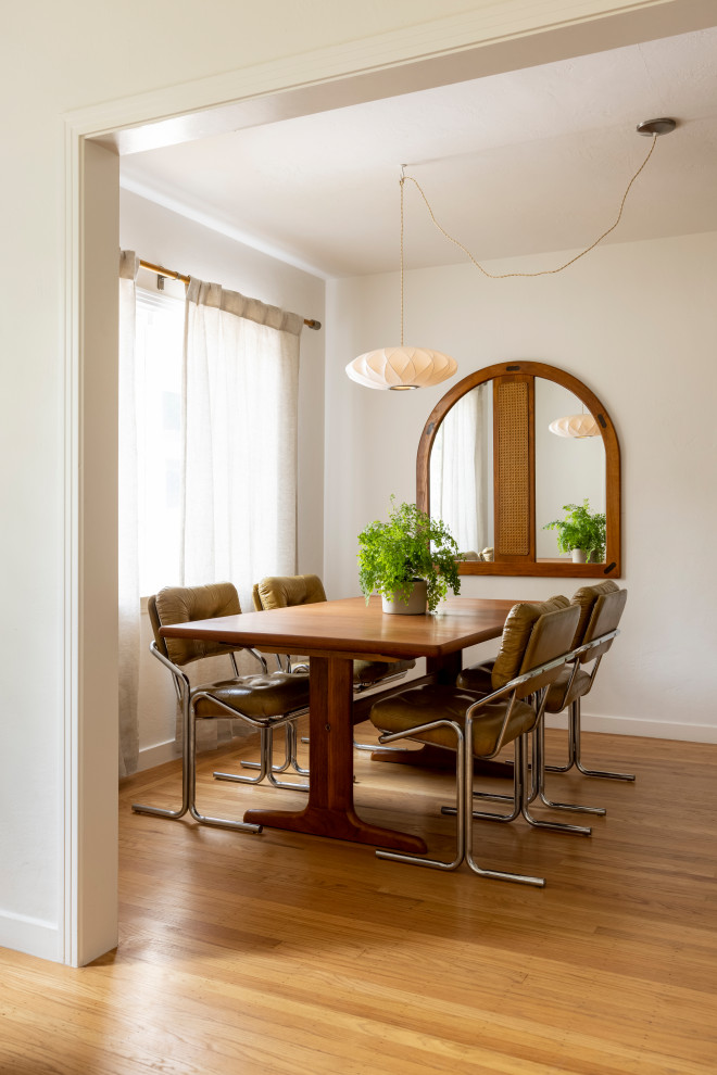 Small transitional dining room in Sacramento with white walls, medium hardwood floors and brown floor.