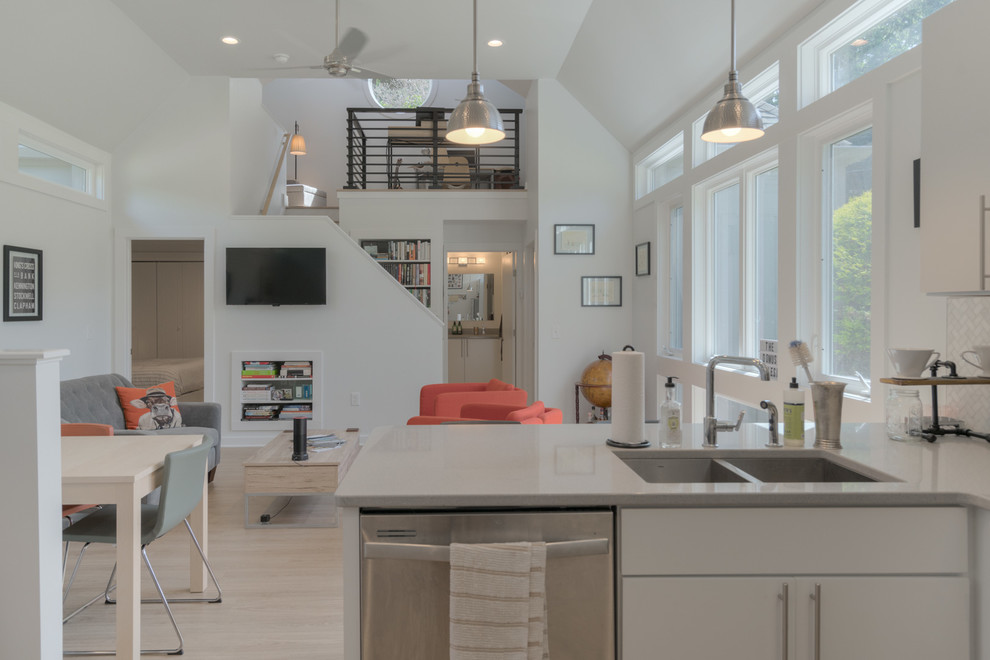 Inspiration for a small modern l-shaped vinyl floor and beige floor open concept kitchen remodel with an undermount sink, flat-panel cabinets, white cabinets, quartz countertops, gray backsplash, marble backsplash and stainless steel appliances