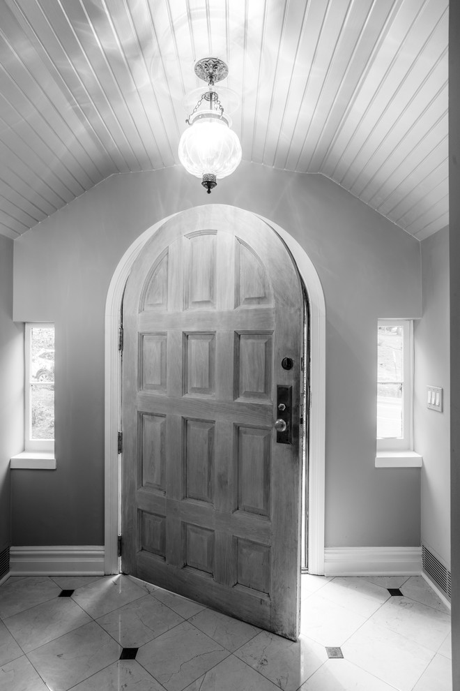 Example of a mid-sized transitional ceramic tile front door design in New York with a medium wood front door