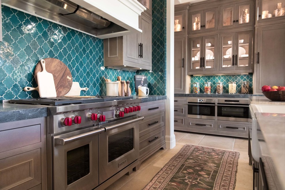 This is an example of a large country l-shaped open plan kitchen in Orange County with a farmhouse sink, recessed-panel cabinets, medium wood cabinets, green splashback, panelled appliances, with island and beige floor.
