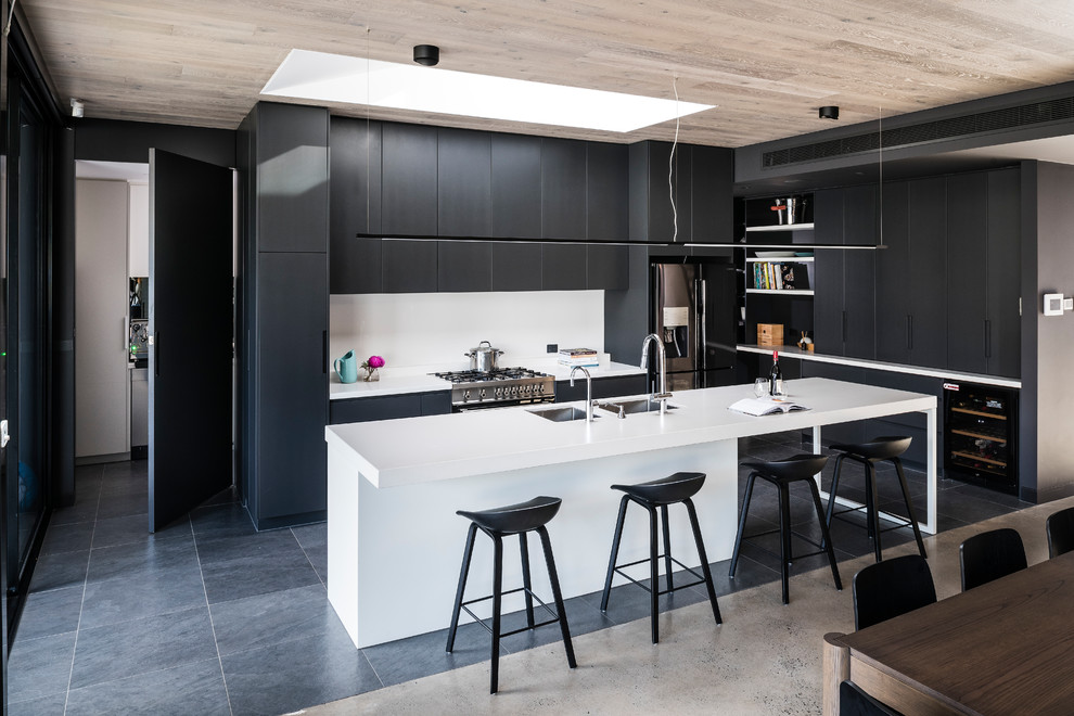 Inspiration for a large modern l-shaped open plan kitchen in Melbourne with an undermount sink, flat-panel cabinets, black cabinets, quartz benchtops, white splashback, glass sheet splashback, stainless steel appliances, porcelain floors, with island, grey floor and white benchtop.