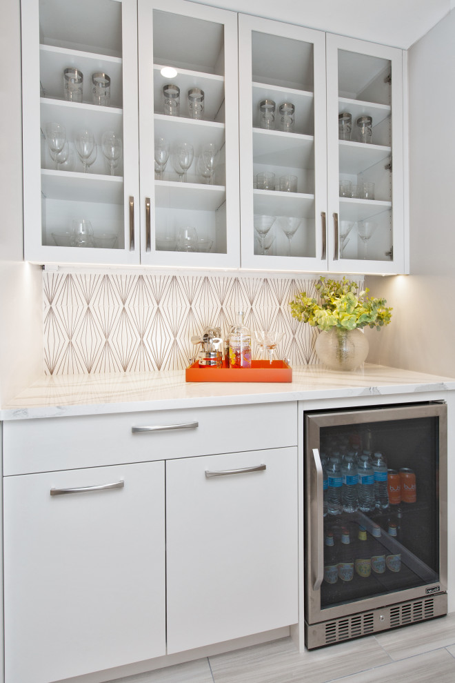 Mid-sized contemporary galley home bar in Minneapolis with white cabinets, white splashback, ceramic splashback, light hardwood floors, grey floor and white benchtop.