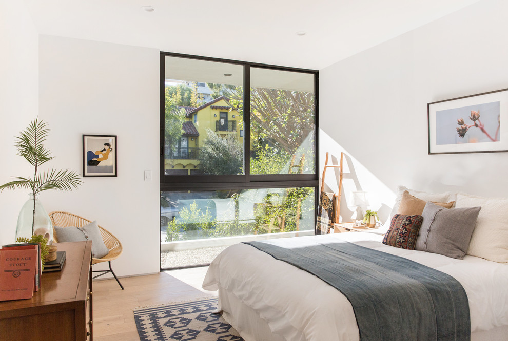 Contemporary bedroom in Los Angeles with white walls, light hardwood floors and beige floor.