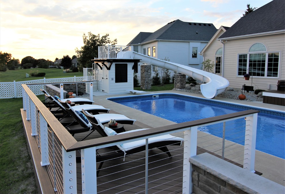 Example of a mid-sized transitional backyard pool design with a fire pit and a roof extension