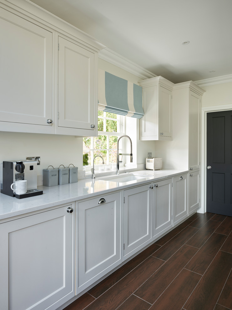 This is an example of a large transitional open plan kitchen in Buckinghamshire with shaker cabinets and with island.