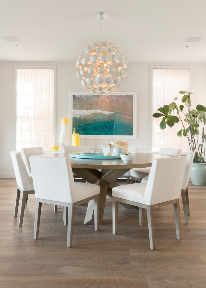 This is an example of a contemporary dining room in San Francisco with white walls, medium hardwood floors and brown floor.