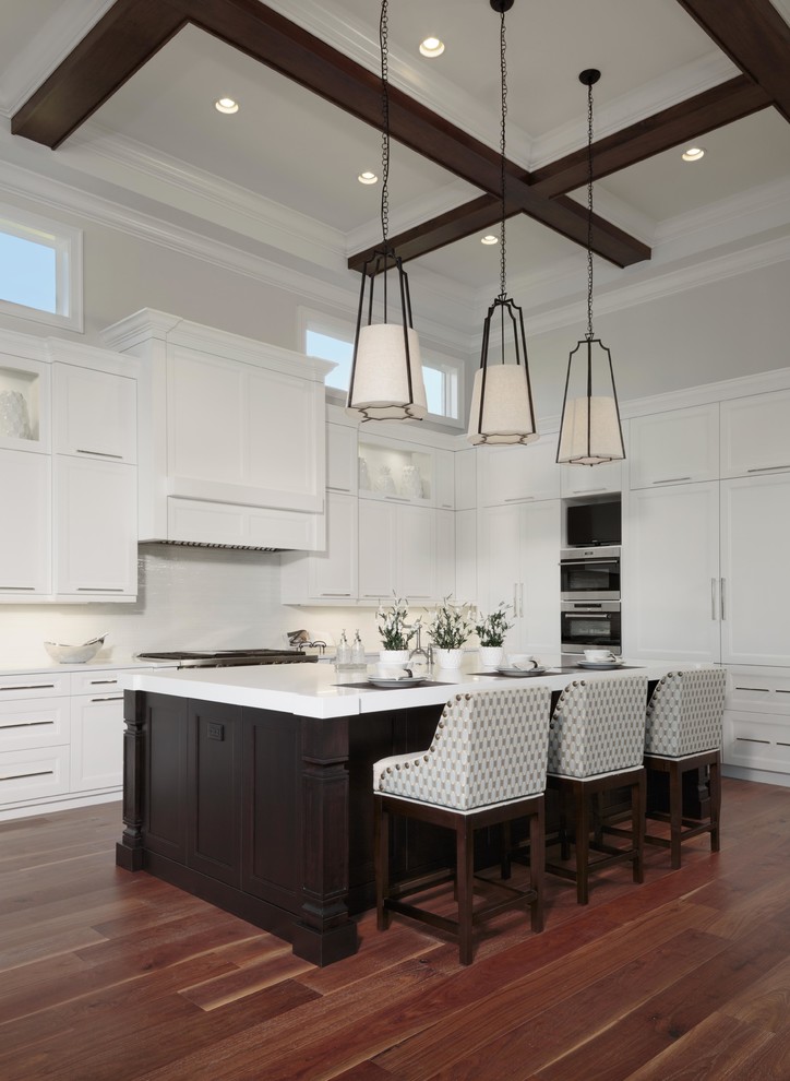 Design ideas for a large transitional l-shaped eat-in kitchen in Miami with shaker cabinets, white cabinets, white splashback, stainless steel appliances, with island, brown floor, quartzite benchtops and dark hardwood floors.