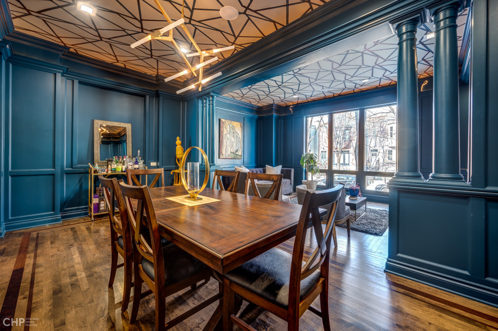 Photo of an expansive eclectic dining room in Chicago with blue walls, medium hardwood flooring, a standard fireplace, a tiled fireplace surround and a wallpapered ceiling.