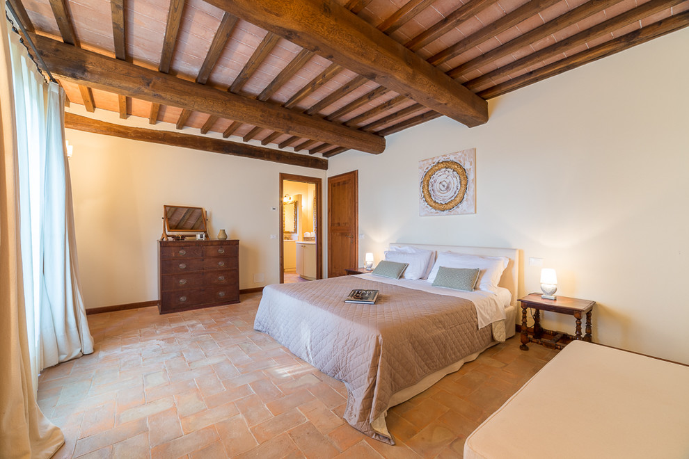 Design ideas for a large country master bedroom in Florence with white walls, terra-cotta floors and red floor.