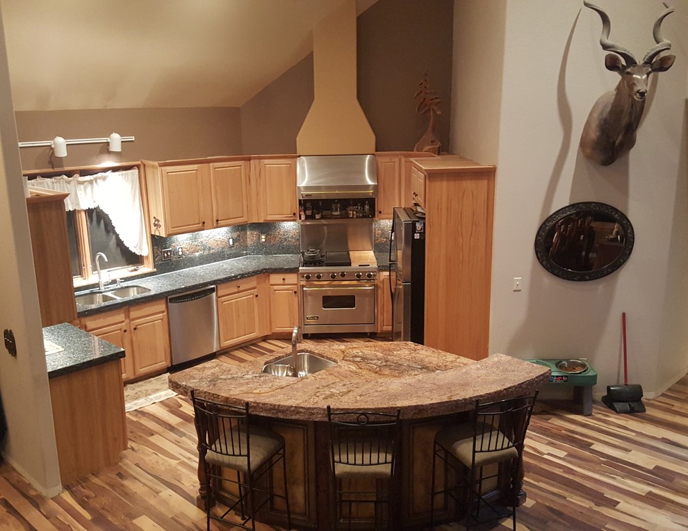 Example of a large mountain style medium tone wood floor eat-in kitchen design in Denver with an undermount sink, light wood cabinets, granite countertops, blue backsplash, stone tile backsplash, stainless steel appliances and an island