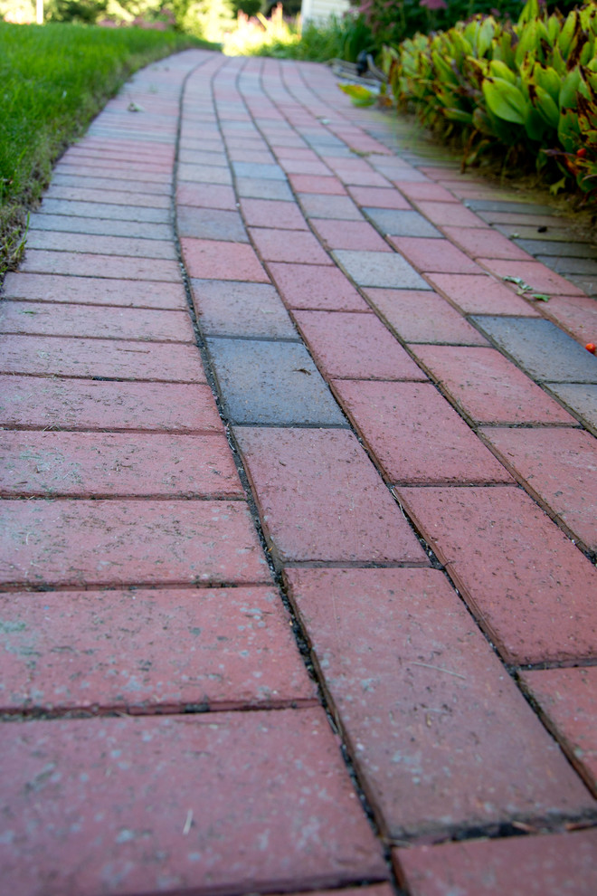 Inspiration for a large traditional front yard full sun driveway in Boston with brick pavers.