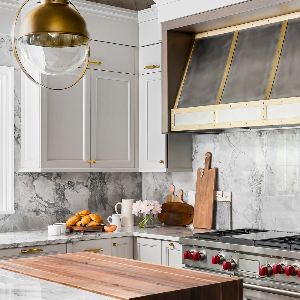 Mid-sized transitional medium tone wood floor and brown floor enclosed kitchen photo in Chicago with a farmhouse sink, recessed-panel cabinets, gray cabinets, quartzite countertops, gray backsplash, stone slab backsplash, paneled appliances, an island and gray countertops