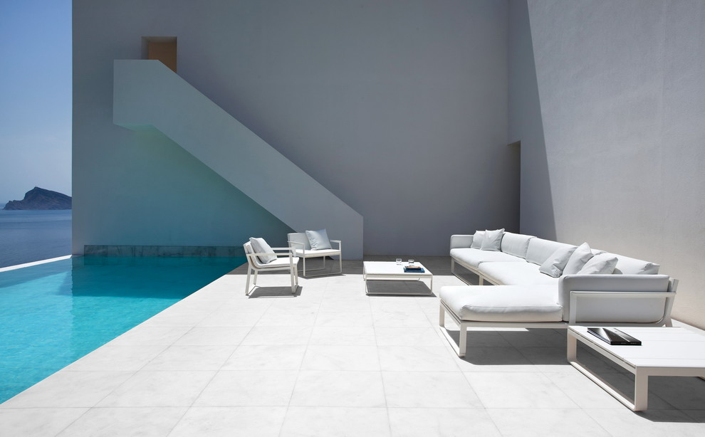 Photo of an expansive contemporary front yard patio in Valencia with concrete pavers.