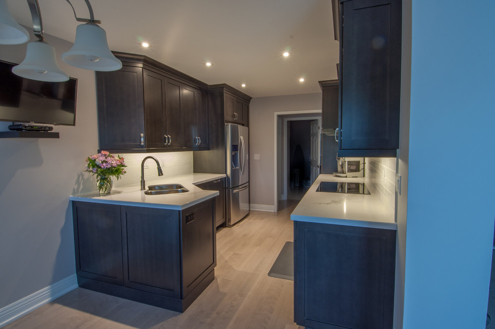 Inspiration for a small modern galley eat-in kitchen in Toronto with a double-bowl sink, shaker cabinets, dark wood cabinets, white splashback, subway tile splashback, stainless steel appliances, dark hardwood floors, no island and marble benchtops.