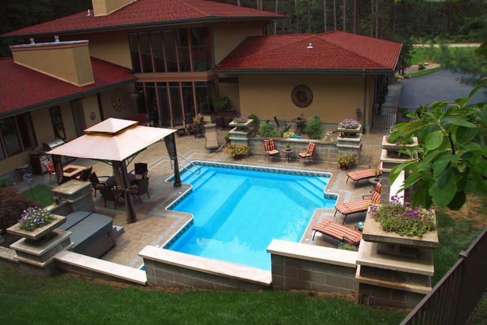Example of a large backyard custom-shaped pool design in Grand Rapids