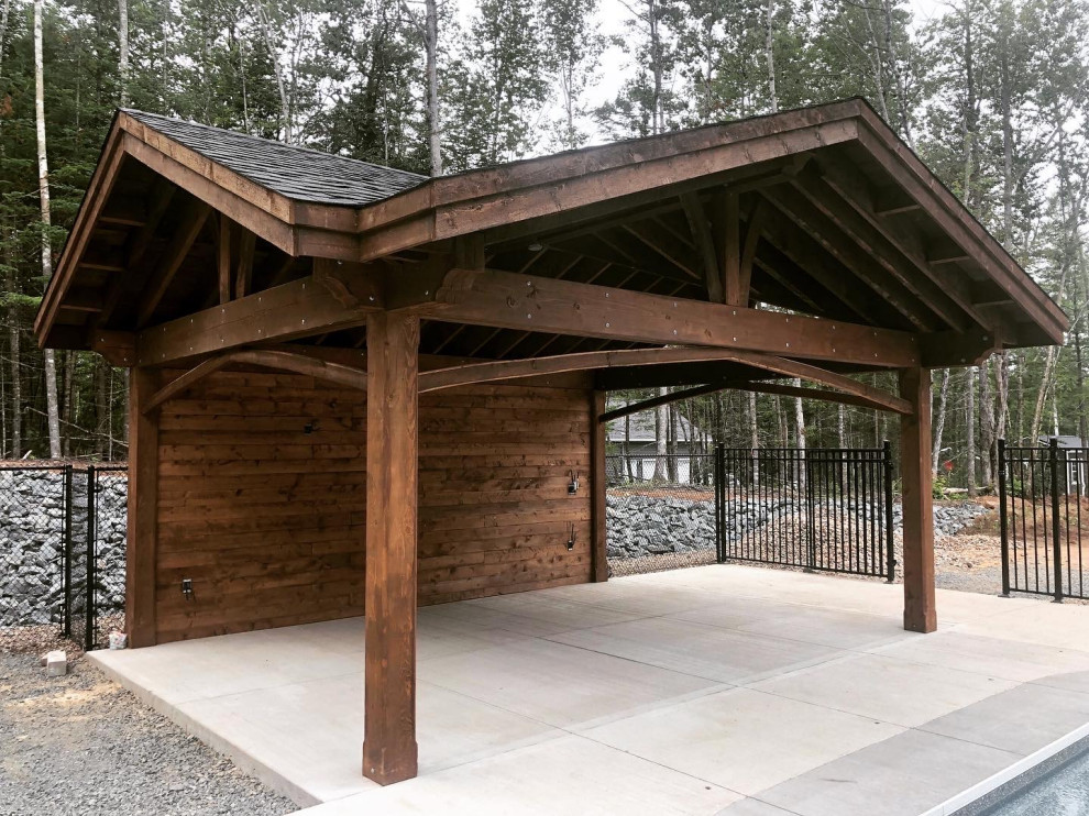 Example of a mid-sized mountain style garage pergola design with a pergola