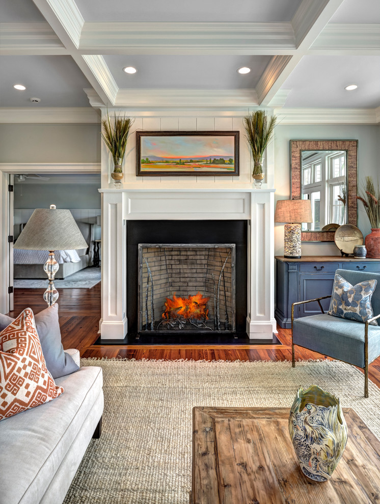 Inspiration for a mid-sized traditional enclosed living room in Charleston with grey walls, medium hardwood floors, a plaster fireplace surround and brown floor.