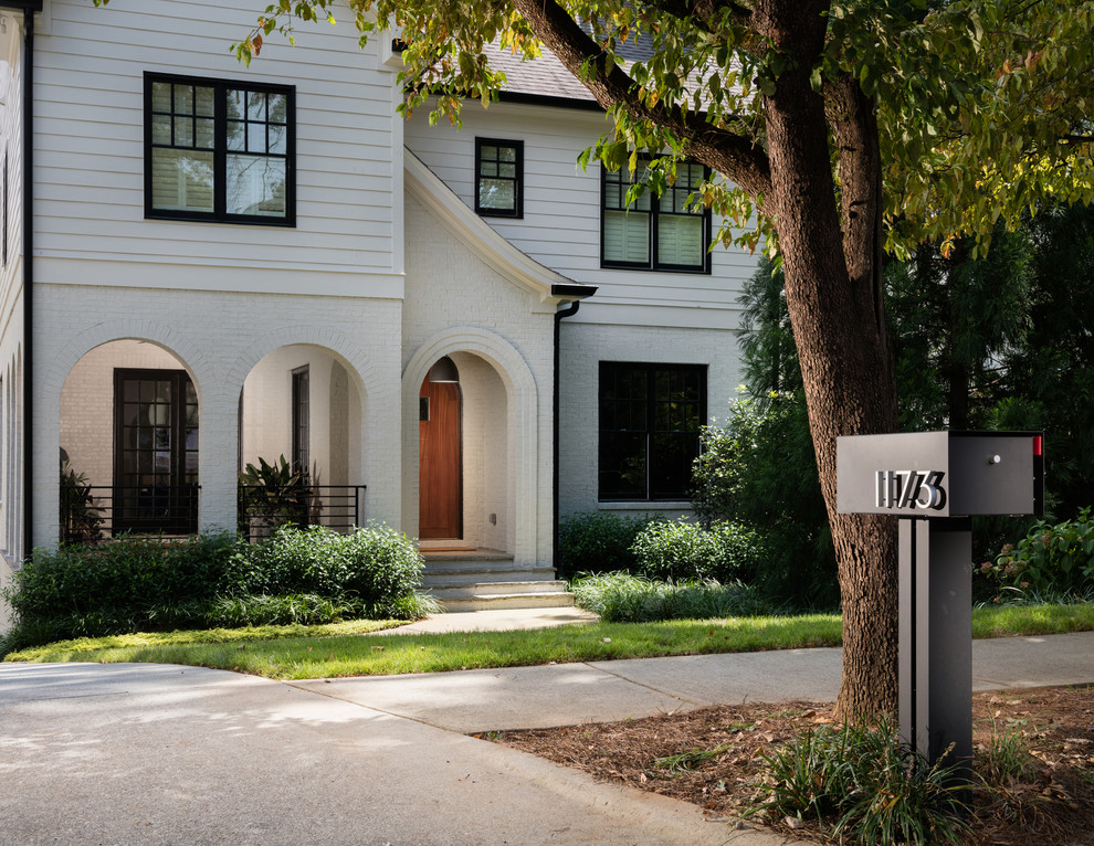 Large contemporary two-storey white house exterior in Atlanta with mixed siding.