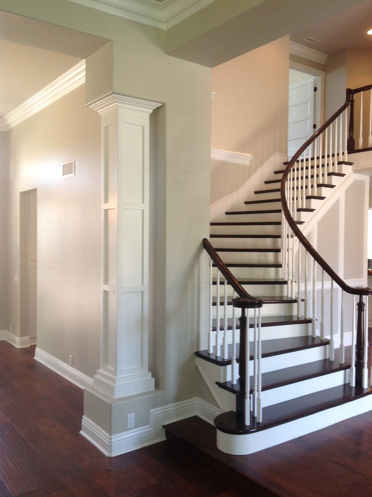 This is an example of a mid-sized traditional wood curved staircase in Los Angeles with painted wood risers.
