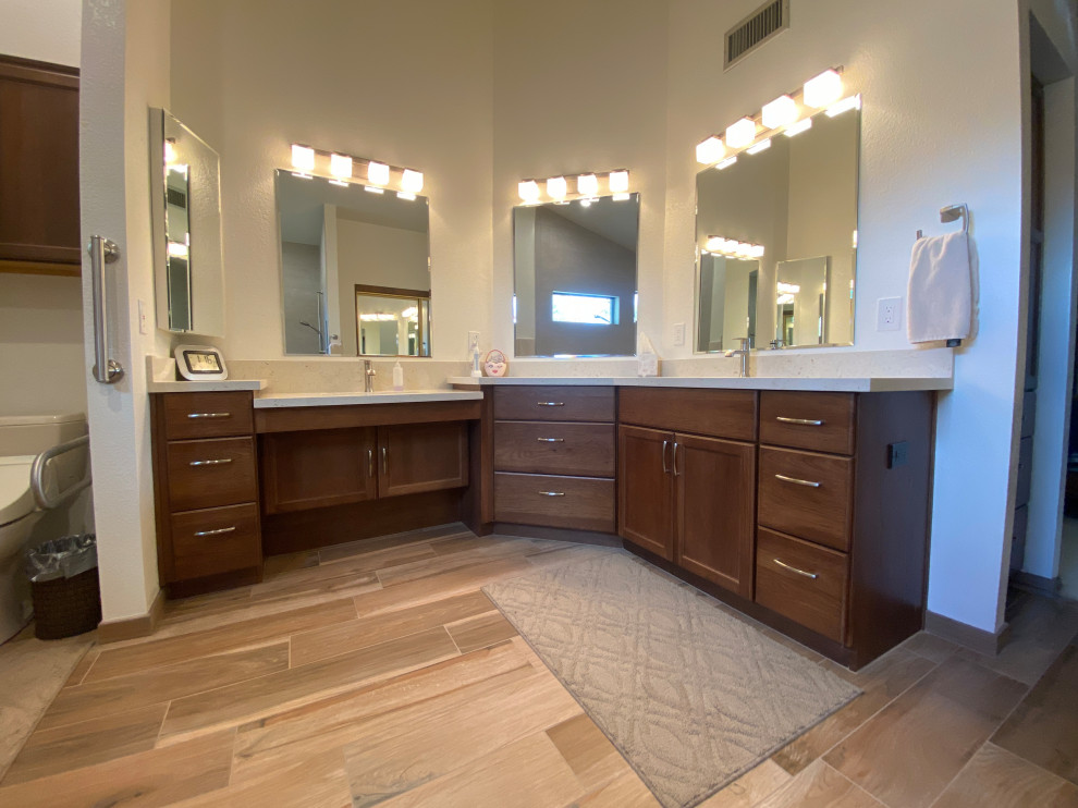 This is an example of a master bathroom in Phoenix with dark wood cabinets, a curbless shower, a shower seat, a double vanity and a built-in vanity.