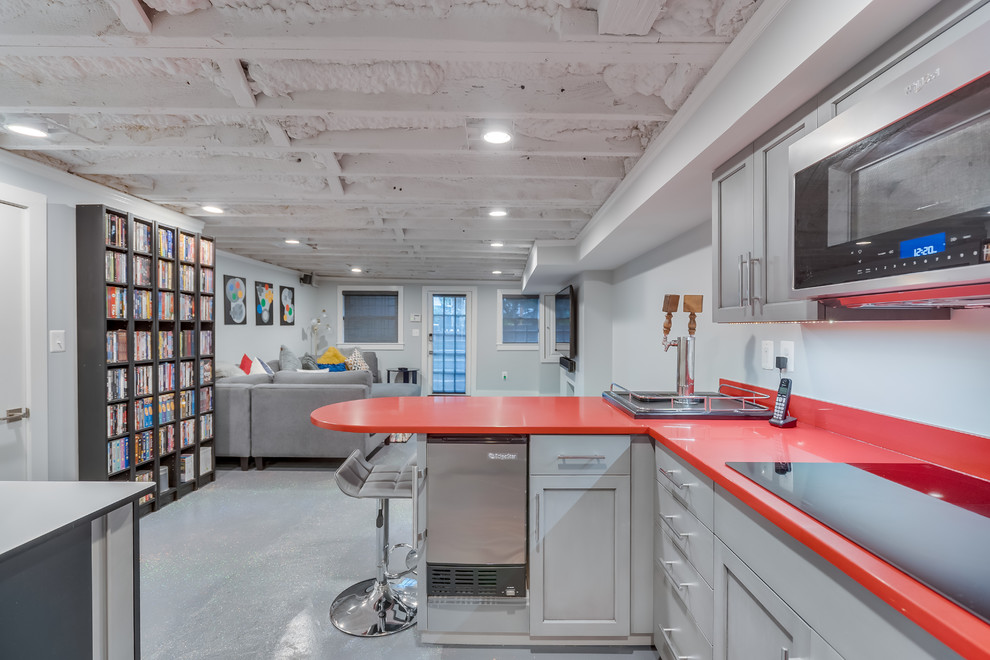 Mid-sized contemporary u-shaped wet bar in DC Metro with an undermount sink, shaker cabinets, grey cabinets, quartz benchtops, concrete floors, grey floor and red benchtop.