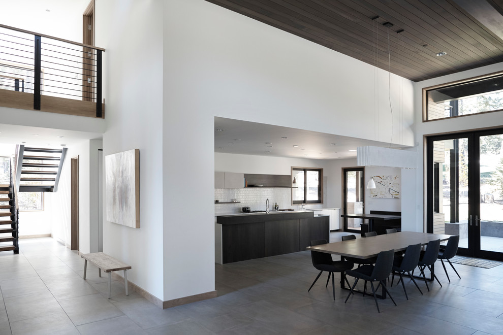 Design ideas for a large modern l-shaped open plan kitchen in San Francisco with an undermount sink, flat-panel cabinets, white cabinets, quartz benchtops, white splashback, ceramic splashback, panelled appliances, porcelain floors and with island.
