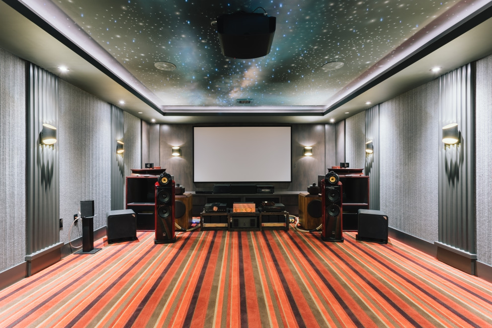 This is an example of a large modern enclosed home theatre in Vancouver with grey walls, carpet, a projector screen and multi-coloured floor.