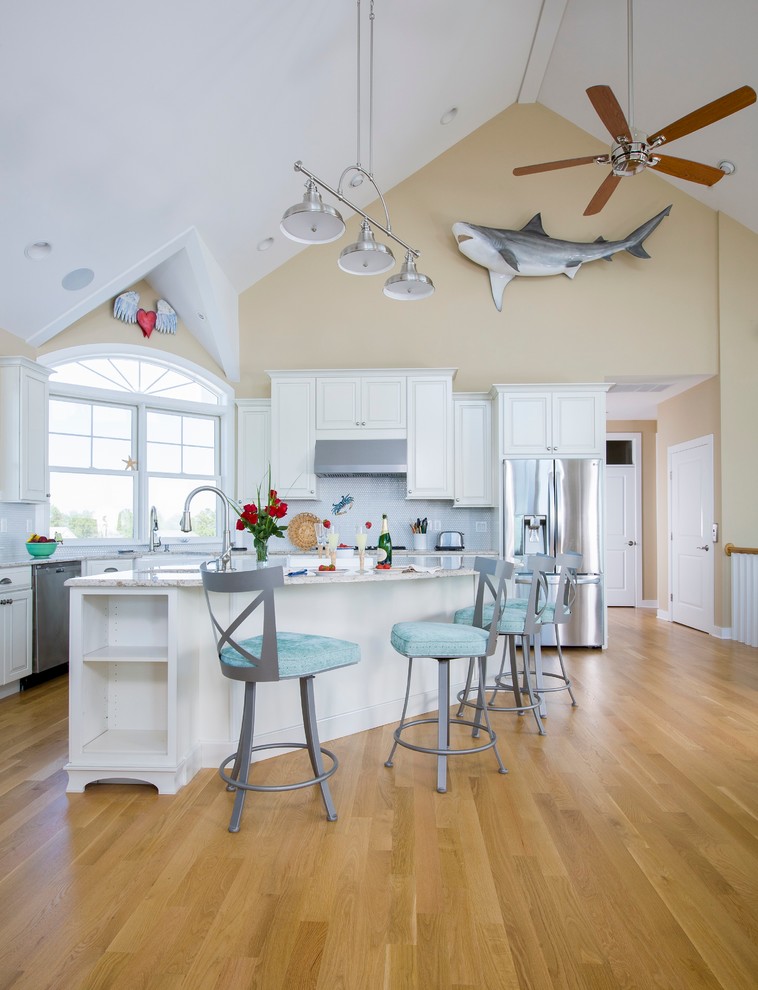 Inspiration for a beach style kitchen in Other with raised-panel cabinets, white cabinets, stainless steel appliances, medium hardwood floors and with island.