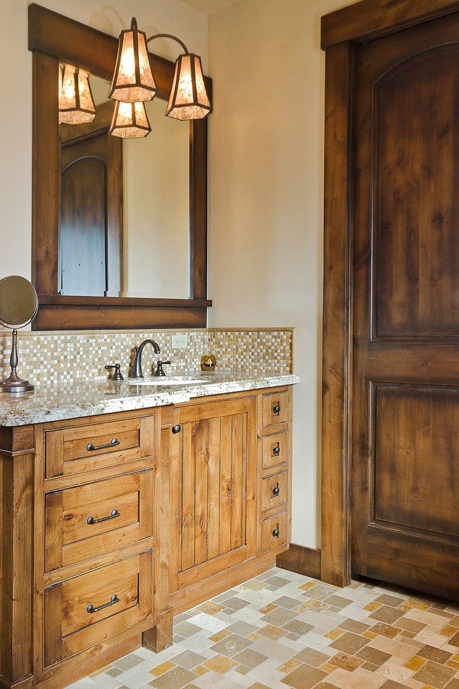 Photo of a country bathroom in Seattle with recessed-panel cabinets, medium wood cabinets, beige tile, multi-coloured tile, mosaic tile, white walls, mosaic tile floors, an undermount sink and granite benchtops.