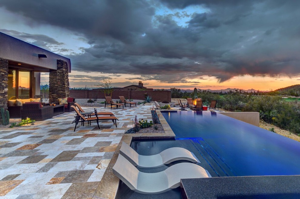 Mid-sized contemporary backyard rectangular infinity pool in Phoenix with a hot tub and stamped concrete.